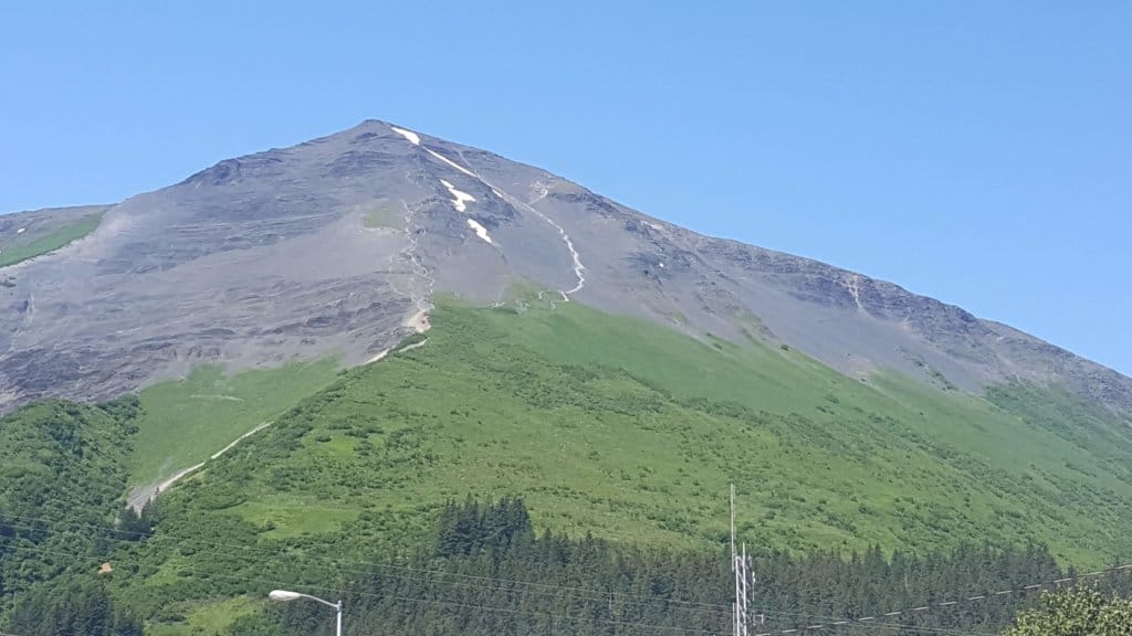 Big mountain with greenery at the bottom and rock at the top