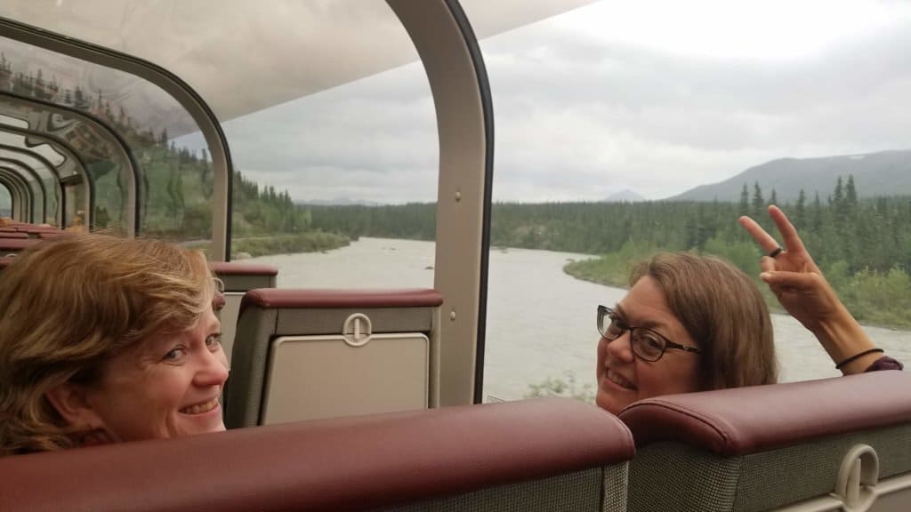 2 female friends riding on a train