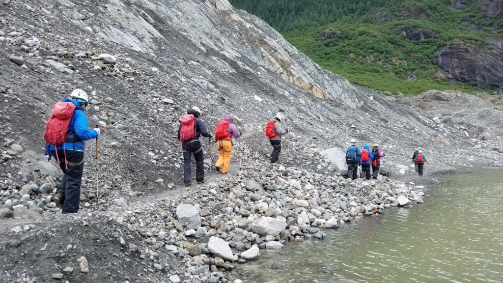 Group of people walking on a rocky shore