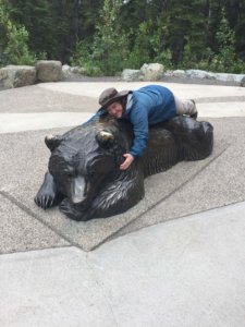 Female laying on a big bronze bear