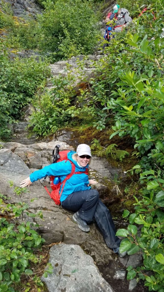 a female climbing on rocks in the woods