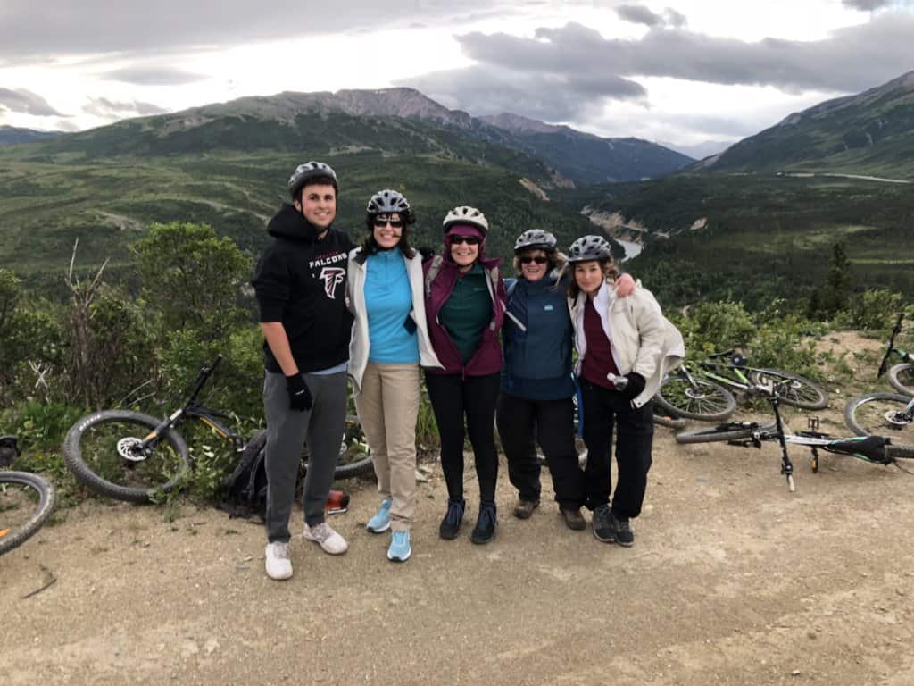 5 friends with bicycles on top of a mountain
