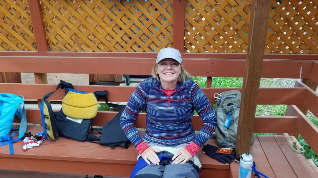 Female smiling sitting on an outside bench