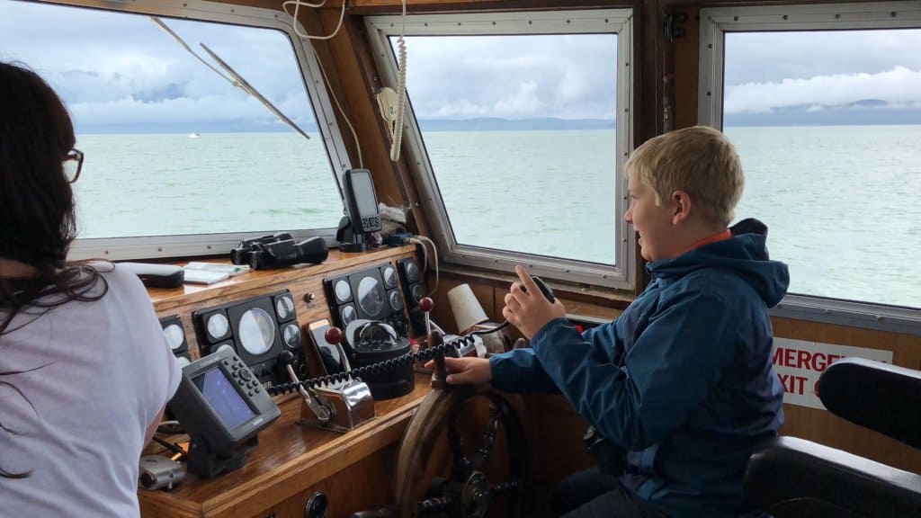 small boy driving a boat