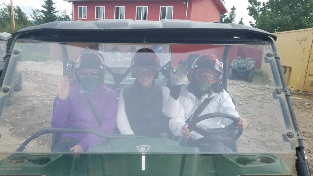 3 females sitting side by side in an ATV