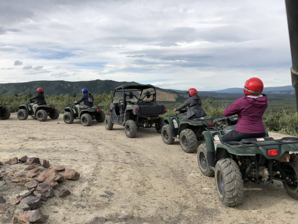 Row of ATVs with people sitting on them