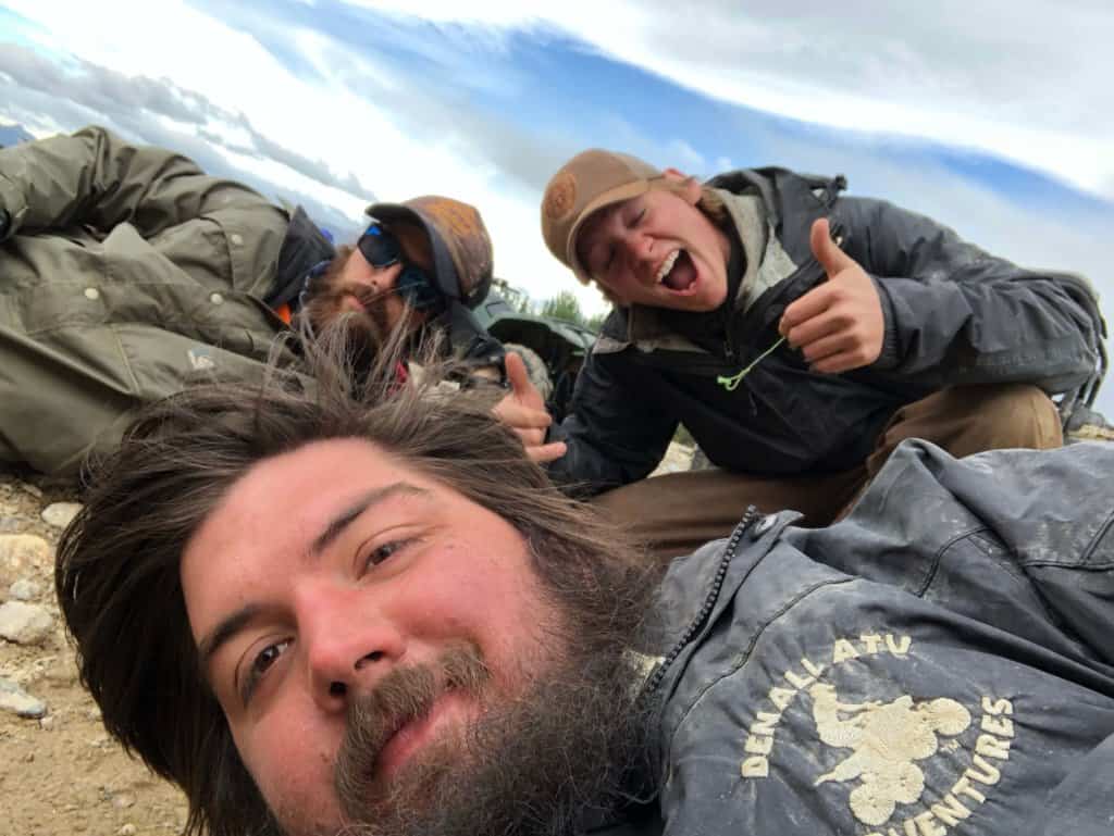 Selfie of 3 men laying on the ground