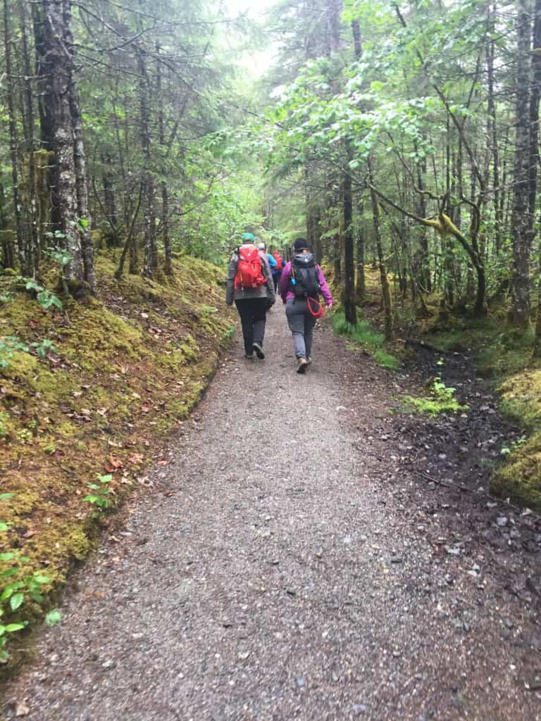 a path in the woods with two females walking