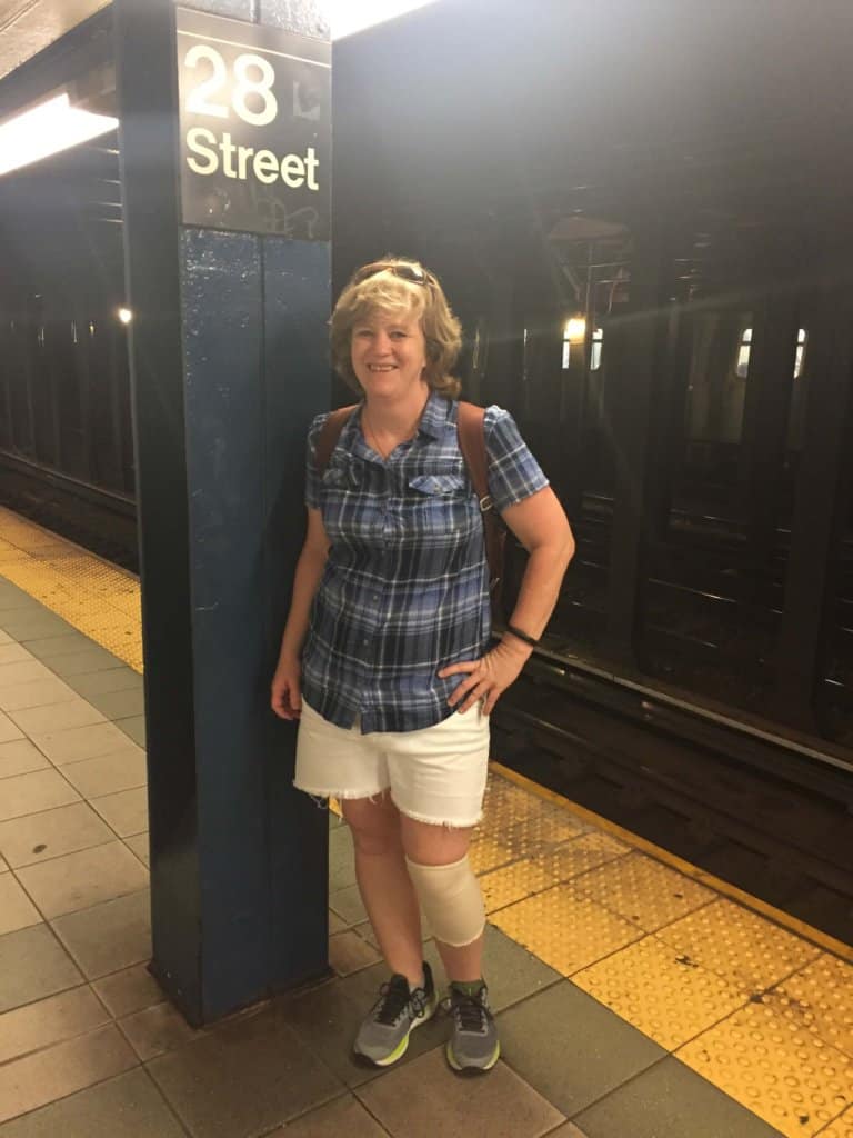 Female waiting on a subway train at 28th Street wearing white shorts and blue top
