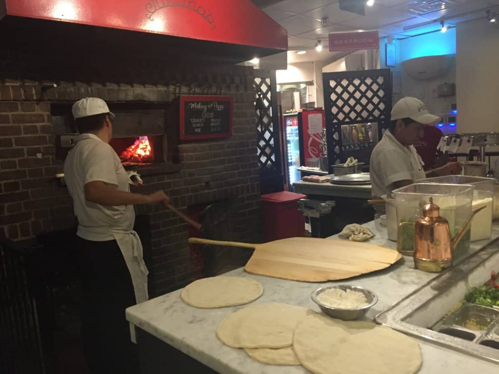 two men making pizzas at a restaurant