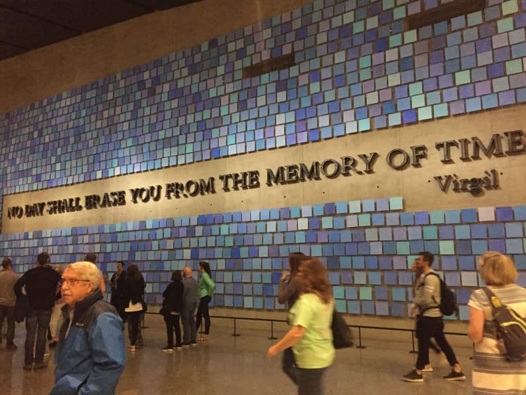 a wall with blue tissues with the words No Day Shall Erase You From The Memory of Time ~Virgil