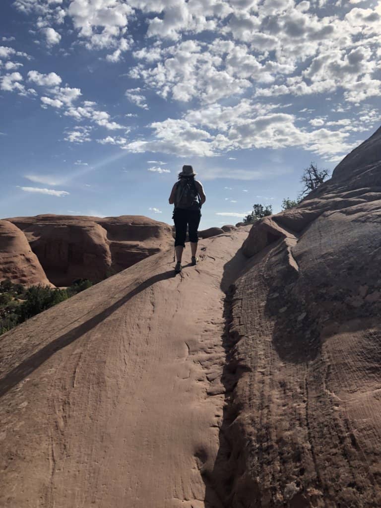 person walking up red rock trail