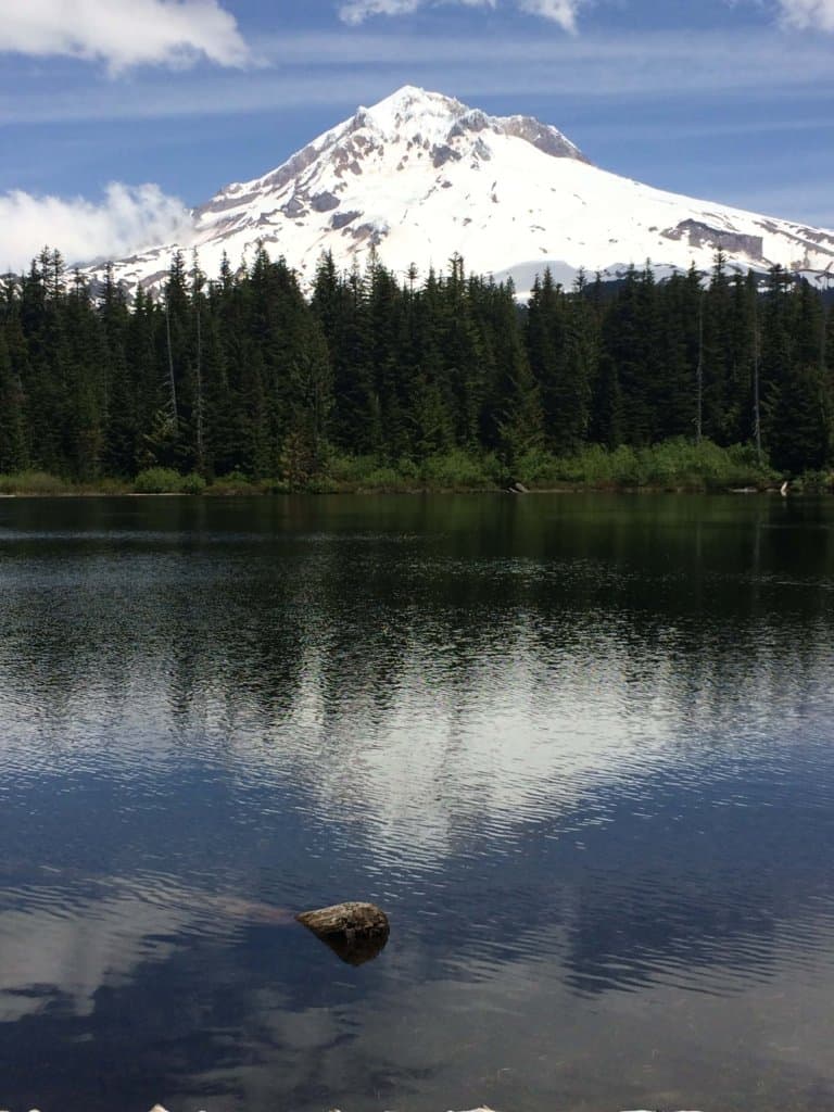 lake in the foreground with snow capped mountain the background