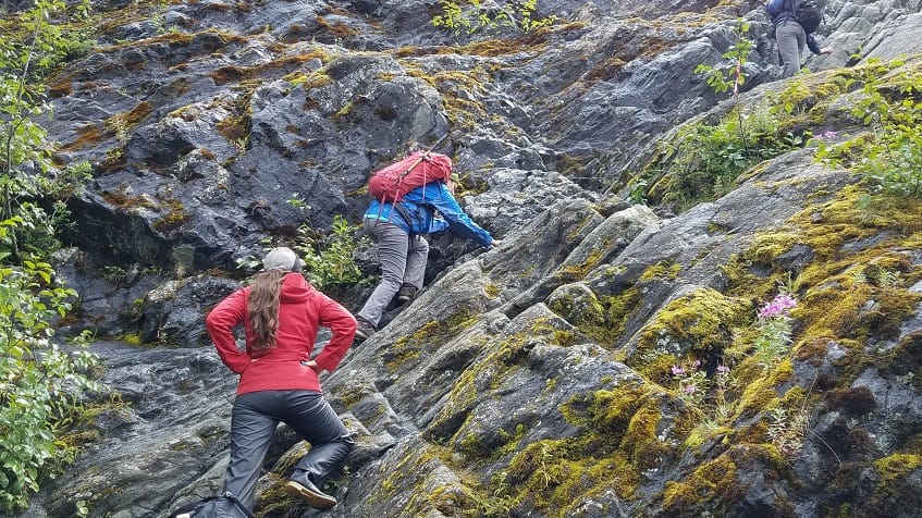 Climbing up rocks hiking in Alaska