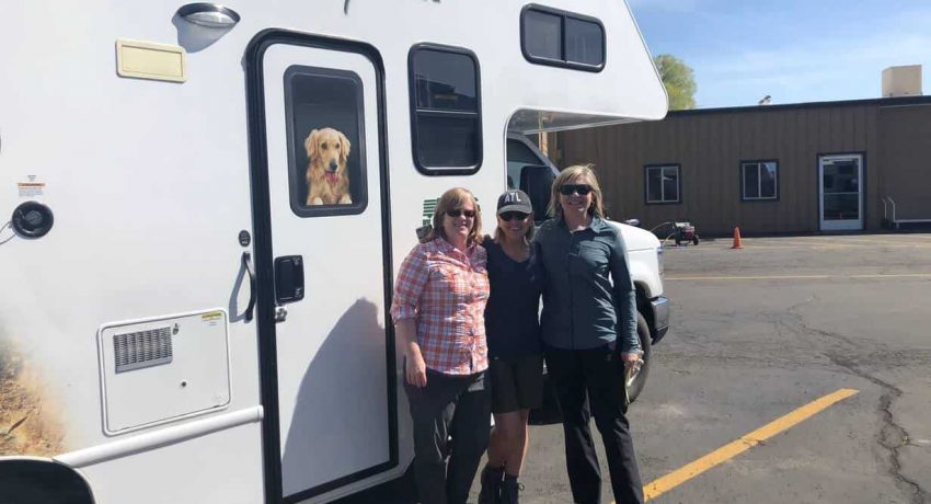 3 women standing in front of a RV